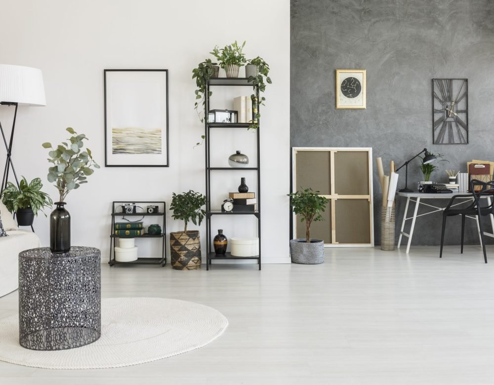 Open space living room Vase on metal table in open space living room with workspace, plants and contrast colors walls