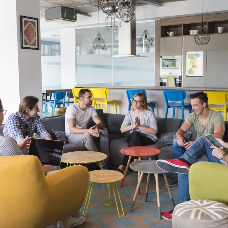 young people group in modern office have team meeting and brainstorming while working on laptop and drinking coffee