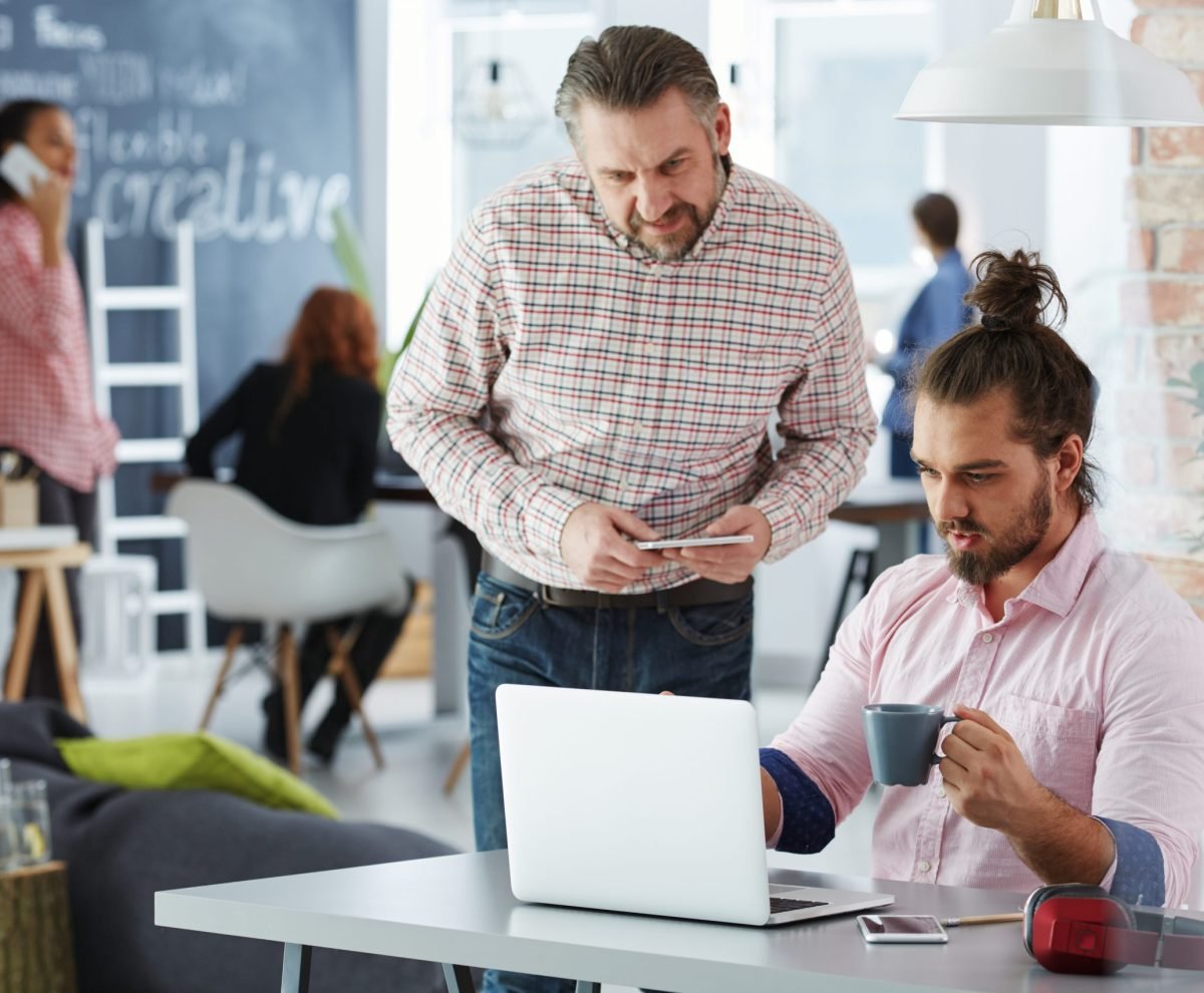 Creative team using laptops and phones in coworking office
